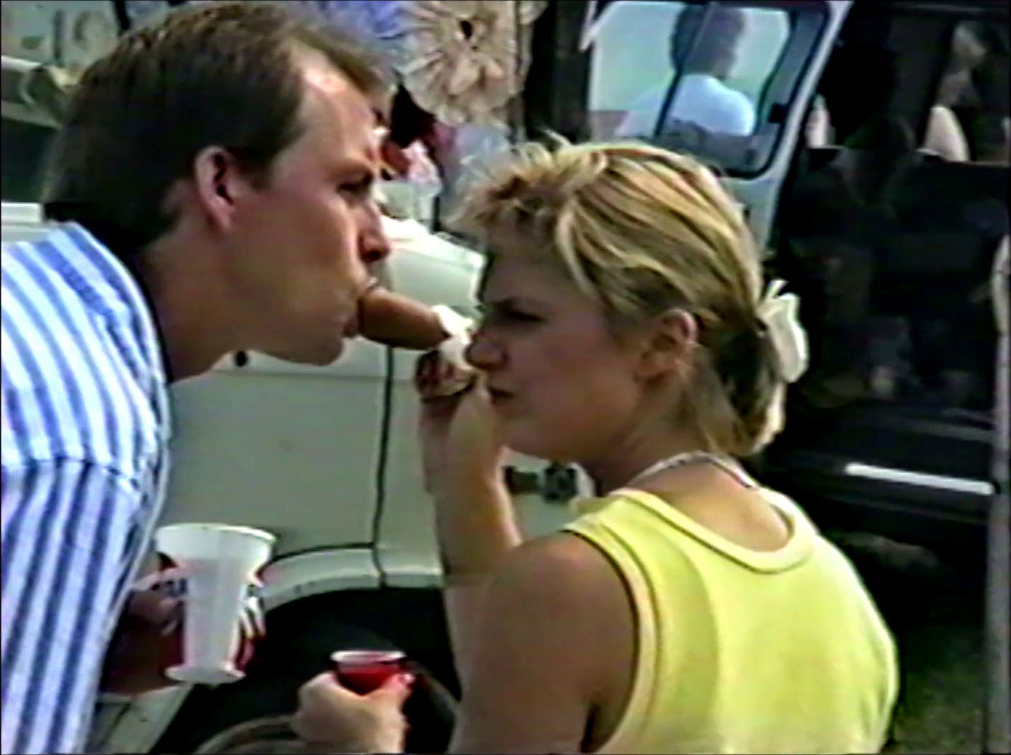 A woman feeding a man hot dog at Collinsville Trade Day.