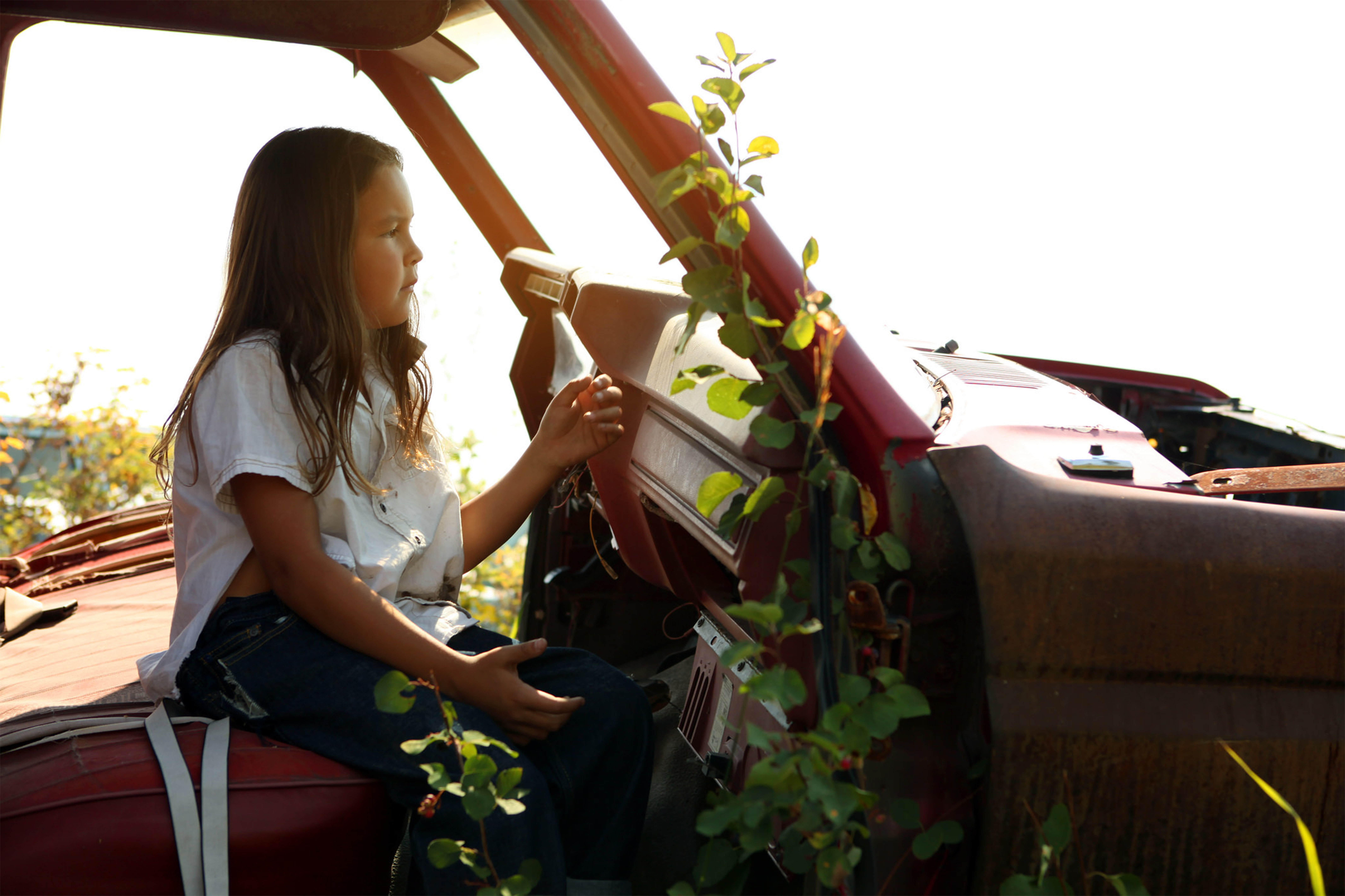 Elias Louie sits in an abandoned car in a 'car cemetery' on the Tl'etinqox reserve while filming 'Clouds of Autumn'.