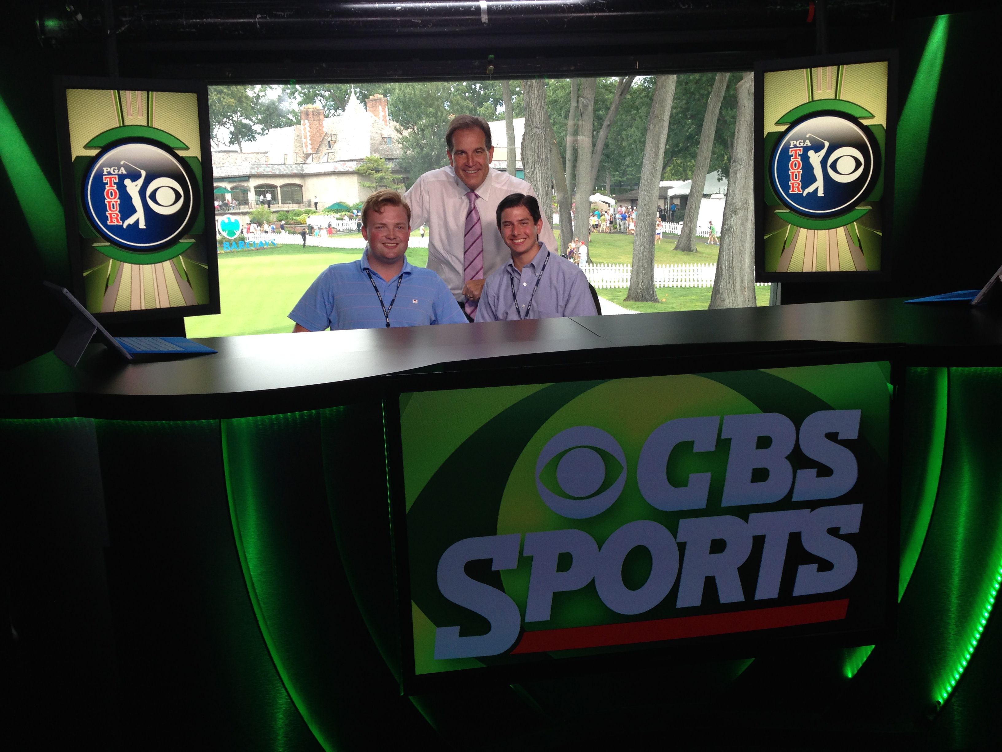 Neil A. Carousso (right) and colleague Rich DeKorte (left) pose for a picture with Jim Nantz (middle) in the CBS Sports studio at the 18th hole at The Barclays 2014 PGA Tour event in Paramus, NJ