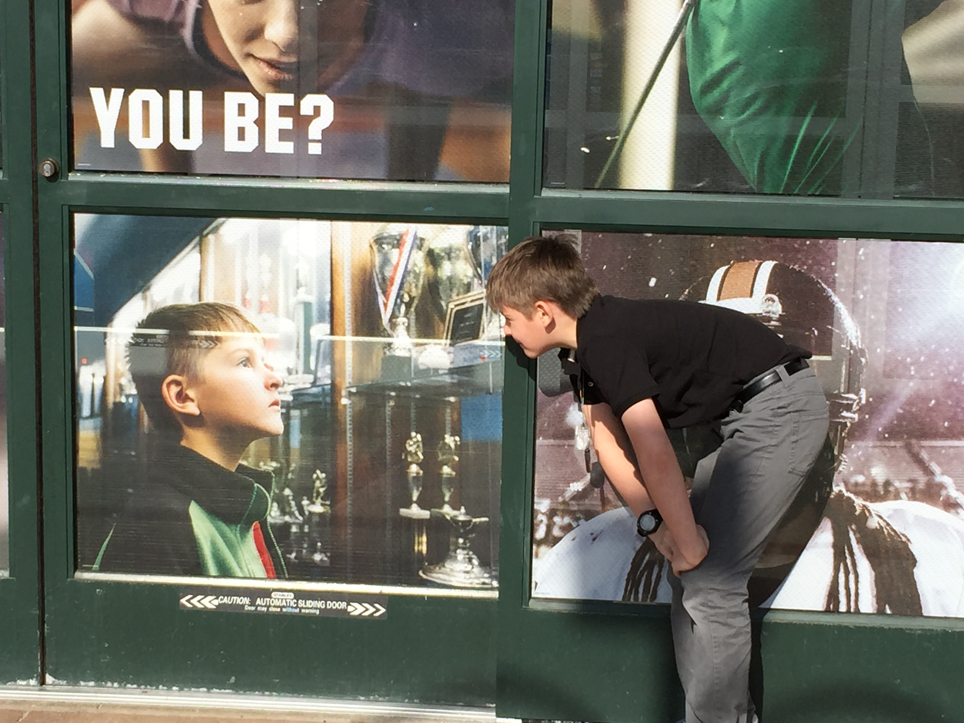 Jack admiring a still photo of himself on the front door of Dicks Sporting Goods (2015)
