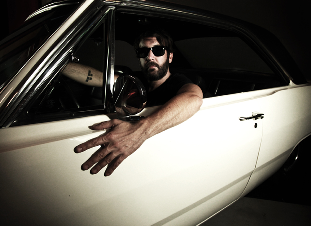 Shevy Shovlin posses in a 1972 Dodge Dart Swinger onset with psychedelic rock group, The Turns in Echo Park, Los Angeles, California U.S.A.
