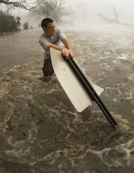 Mike Theiss holding on to a sign in extreme storm surge during Hurricane Katrina in Gulfport, Mississippi.