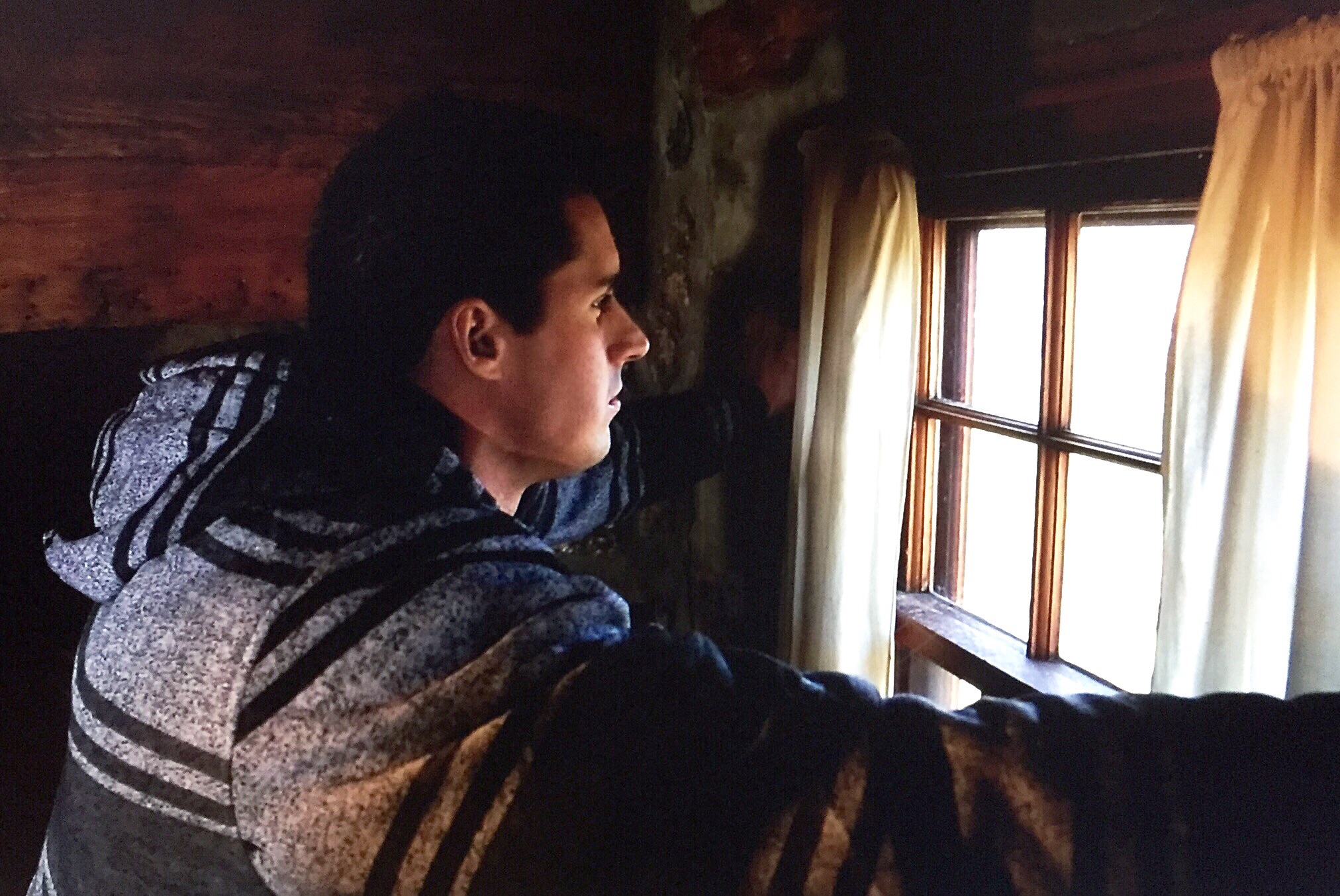 Behind the scenes photo of Keegan taking a moment to peer out the window and look at the stunning landscape.