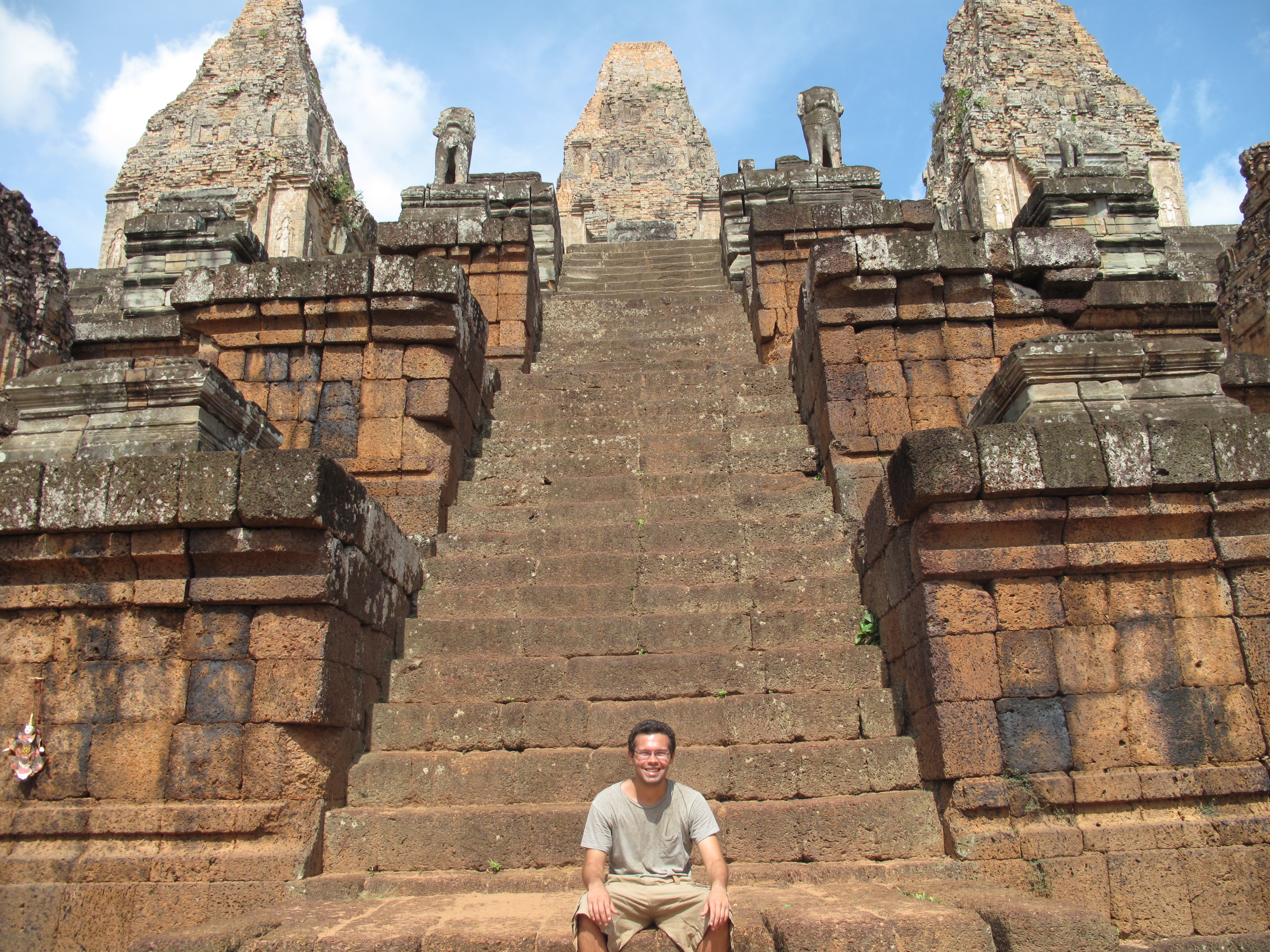 This is a picture of me sitting on a temple in Cambodia.