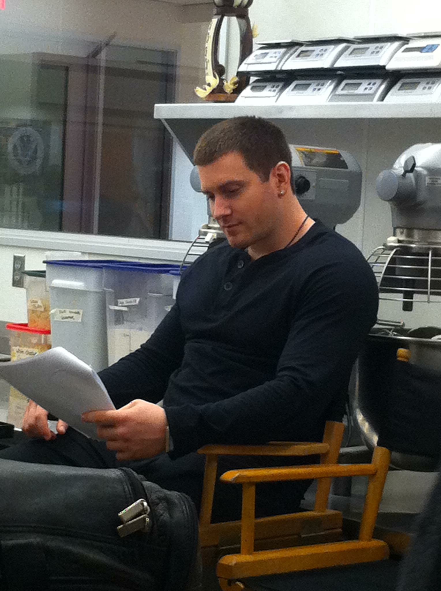 Kyle English studying his lines on the set of 