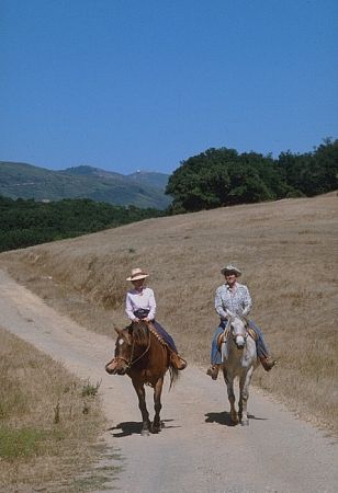 Ronald Reagan riding horses with wife Nancy