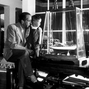 Humphrey Bogart and his son, Stephen, looking at a model of his yacht, 