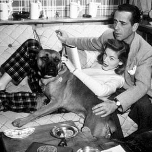 Humphrey Bogart and Lauren Bacall with their pet boxer at home circa 1945