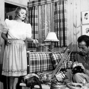 Humphrey Bogart cleaning his fishing tackle with his third wife, Mayo Methot, at home, circa 1944.