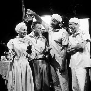 Stranley Kramer, director, with Olivia De Havilland, Robert Mitchum, and Frank Sinatra on the set of 
