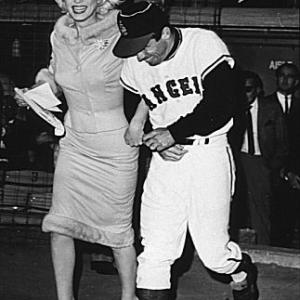 M. Monroe & Angles outfielder Albie Pearson run onto the field at Chavez Ravine. June 1, 1962
