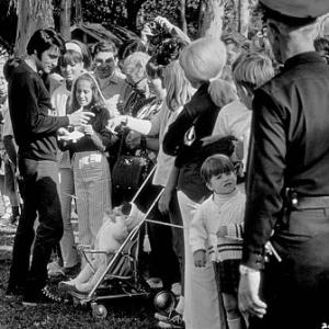 Elvis Presley signing autographs during a break from filming 
