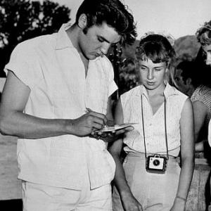 Elvis Presley signing autographs for his fans, circa 1957.