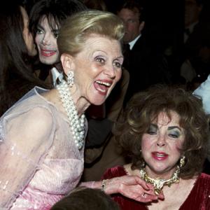 Elizabeth Taylor and Barbara Davis admire each others jewelry at the Carousel of Hope awards dinner at the Beverly Hilton Hotel (Michael Jackson in background)