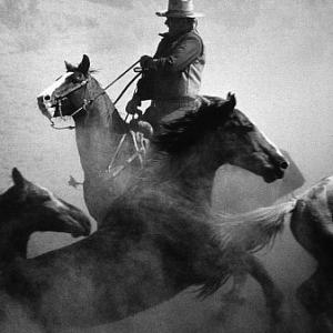 John Wayne riding a horse for 