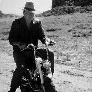 Riding a motorcycle on location for Big Jake National General 1970
