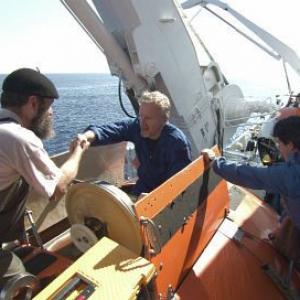 MIR crew members help James Cameron (center) into MIR 1.