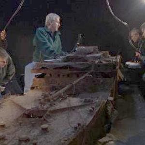 Using a scale model of the wreck of Titanic James Cameron center plans the exploration sequence with his team including MIR 2 pilot Genya Chernaiev second from right holding MIR scale model