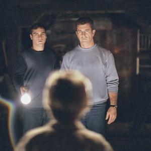 The lives of Graham Hess (Mel Gibson, right) and his brother, Merrill (Joaquin Phoenix, left) are changed forever after finding an intricate pattern of circles and lines carved into their crops