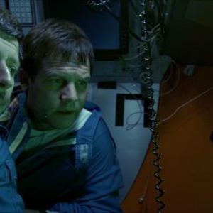 MIR 2 pilot Genya Chernaiev left and Bill Paxton center look through a porthole in the submersible to the wreckage on the deck of Titanic