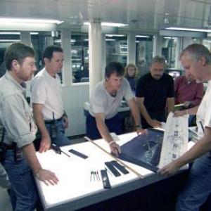 Bill Paxton (center) reviews schematics in a pre-launch discussion led by James Cameron (second from right).