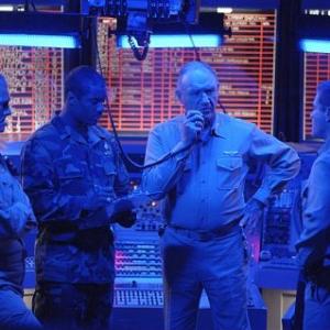 Reigart (GENE HACKMAN, center) communicates with a downed aviator, while planning a daring rescue mission with (left-right) the carrier commanding officer (TOM MOONEY), Rodway (CHARLES MALIK WHITFIELD) and O'Malley (DAVID KEITH).