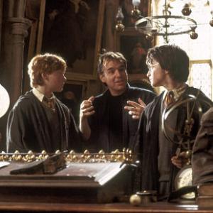 Director CHRIS COLUMBUS center on the set with DANIEL RADCLIFFE right and RUPERT GRINT in Warner Bros Pictures Harry Potter and the Chamber of Secrets