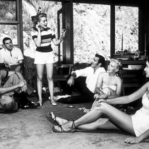 Rock Hudson at home playing charades with Leonard Stern (script writer), Lori Nelson (actress), Bob Preble (actor), Julia Adams (actress), and Betty Abbott (script girl), North Hollywood, CA, 1952.