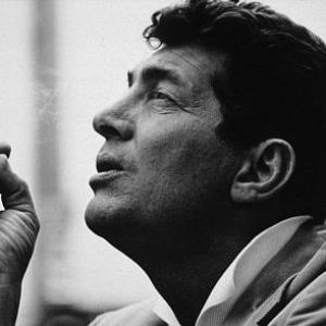 Dean Martin smoking a cigarette during a break from his television show in Hollywood, 1961. Modern silver gelatin, 11x14, signed. © 1978 Sid Avery MPTV
