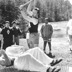 Demonstrating that his PerkiSystem total fitness program builds strong bodies, health nut Tony Perkis (Ben Stiller, supine) proves his point on a bed of nails as the awestruck campers witness Lars (Tom Hodges, center) smashing a block of ice on Tony's brick-hard stomach.