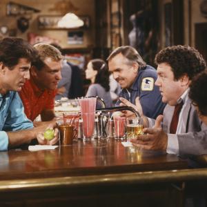 Still of Woody Harrelson, Ted Danson, John Ratzenberger, George Wendt, Johnny Gilbert and Rhea Perlman in Cheers (1982)
