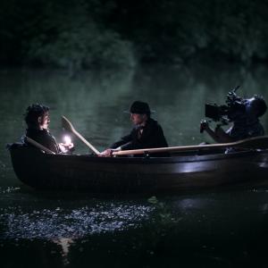 Jeremy hand holds a camera in a canoe during the filming of 