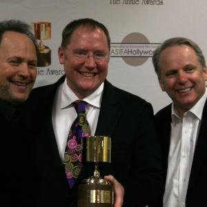 Presenter Billy Crystal congratulates Ub Iwerks award winners John Lasseter and Nick Park