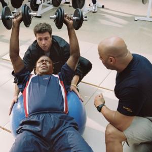 Stan Ross (Bernie Mac, lower left) hits the weight room with Boca (Michael Rispoli, upper left) and Brewers team conditioning coach (Scott Brooks, right) to prepare for his unlikely baseball comeback.