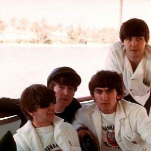 The Beatles, (Ringo Starr, John Lennon, George Harrison, Paul McCartney) on board a boat.