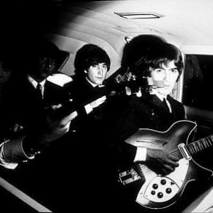 The Beatles (Paul McCartney, Ringo Starr, John Lennon, & George Harrison) inside the car with their guitars. c. 1964