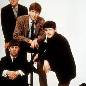 The Beatles, with John Lennon on the stool surrounded by the rest of the group,