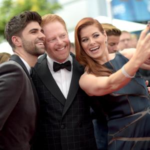 Debra Messing Jesse Tyler Ferguson and Justin Mikita at event of The 66th Primetime Emmy Awards 2014