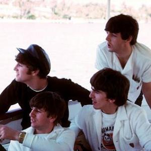 The Beatles, (John Lennon, Ringo Starr, George Harrison, Paul McCartney) on a boat looking overboard,
