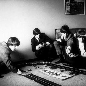The Beatles (George Harrison, Ringo Starr, Paul McCartney and John Lennon playing with their miniature race tracks.) c. 1964