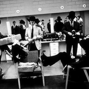 The Beatles (Paul McCartney, Ringo Starr, George Harrison, and John Lennon inside the dressing room with their cowboy hats on) c. 1964