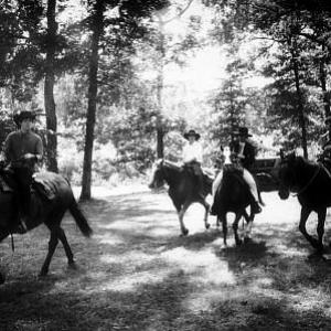 The Beatles (Paul McCartney, George Harrison, John Lennon, and Ringo Starr on horseback into the woods) in Ozarks, Arkansas c. 1965