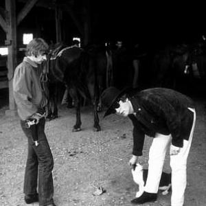 The Beatles (Ringo Starr and John Lennon in the stables. John pets a kitty cat) c. 1965