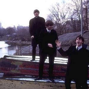 the Beatles Ringo Starr John Lennon and Paul McCartney on top of some over turned boats