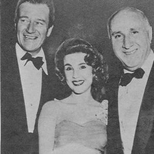 Stars John Wayne, Karen Sharpe, and composer Dimitri Tiomkin celebrate the premiere of 