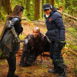 Mairzee ALmas directs Marie Avgeropouos and Ricky Whittle on the set of The 100