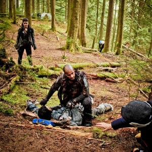 Mairzee Almas directs Marie Avgeropoulos and Ricky Whittle on the set of The 100