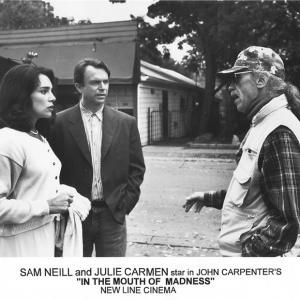 Julie Carmen and Sam Neill with director John Carpenter on set of IN THE MOUTH OF MADNESS