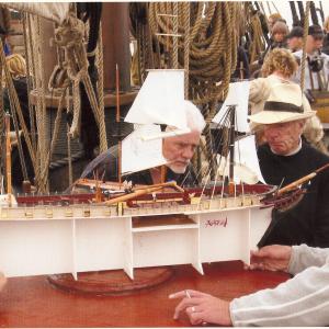 Director, Peter Weir and Supervising Art Director, Bruce Crone observing the detailed model of the ship 