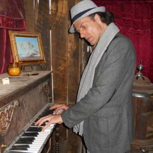 Actor writer director Philippe Durand playing piano in Doc Hollidays poker and faro room